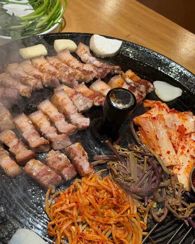 잘 구워진 삼겹살과 곁들임 채소