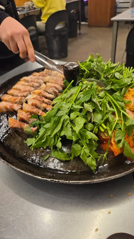 직원이 미나리를 듬뿍 올려주는 모습