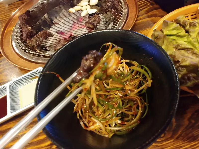 잘 구워진 고기와 파절이를 함께 집어 올린 모습