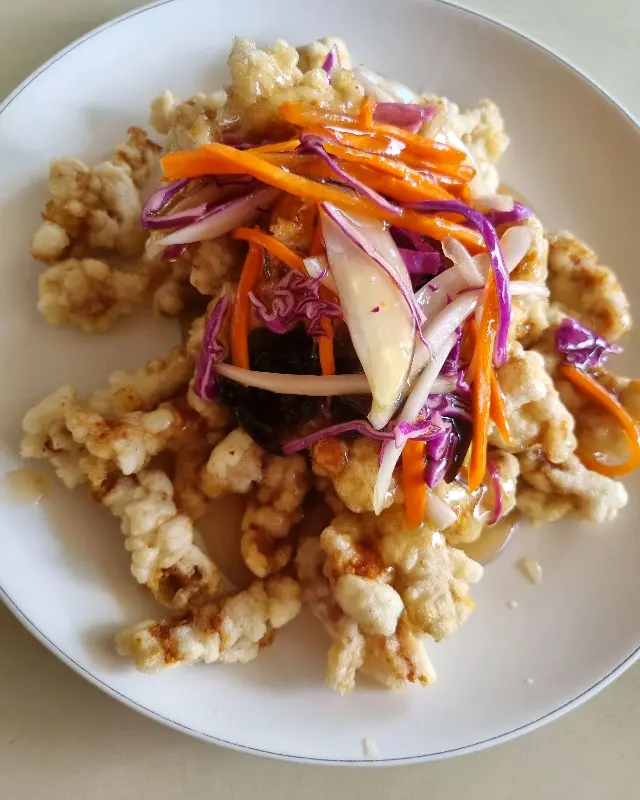 채 썬 야채가 탕수육 위에 듬뿍 올려진 모습