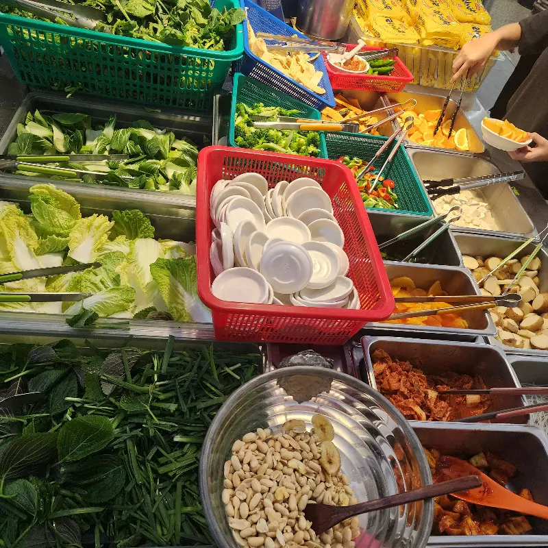 샐러드바에 놓인 다양한 야채와 반찬들