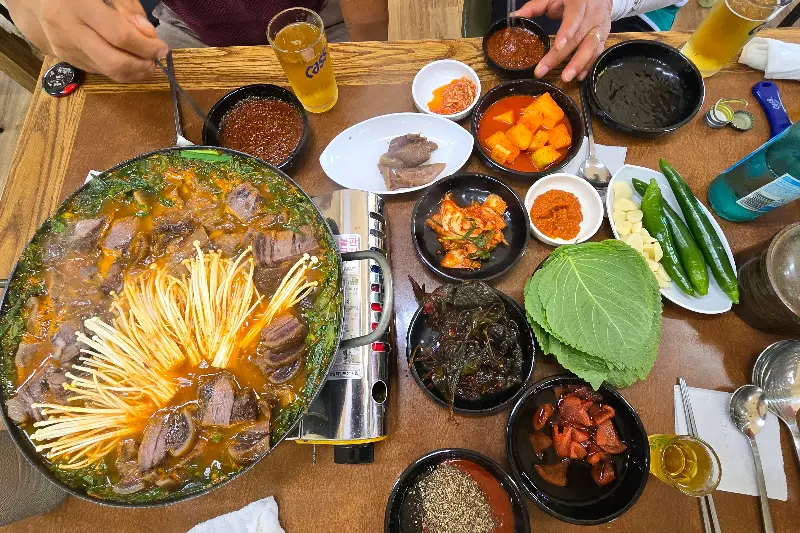 전골과 다양한 밑반찬이 차려진 푸짐한 상차림