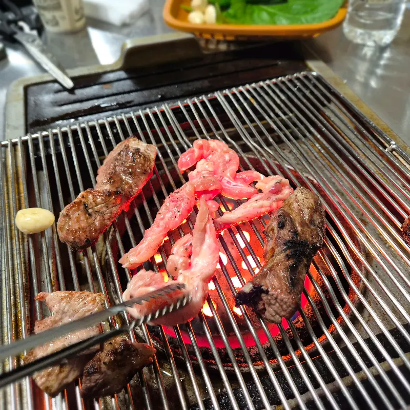 연탄불에 구워지는 돼지꼬리와 돼지생갈비