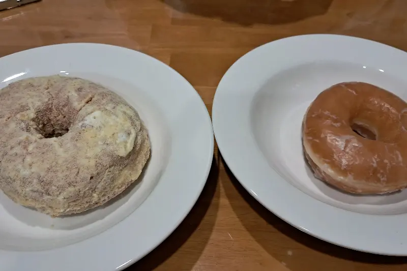 접시에 담긴 흑임자 도넛과 페이머스 글레이즈드 도넛