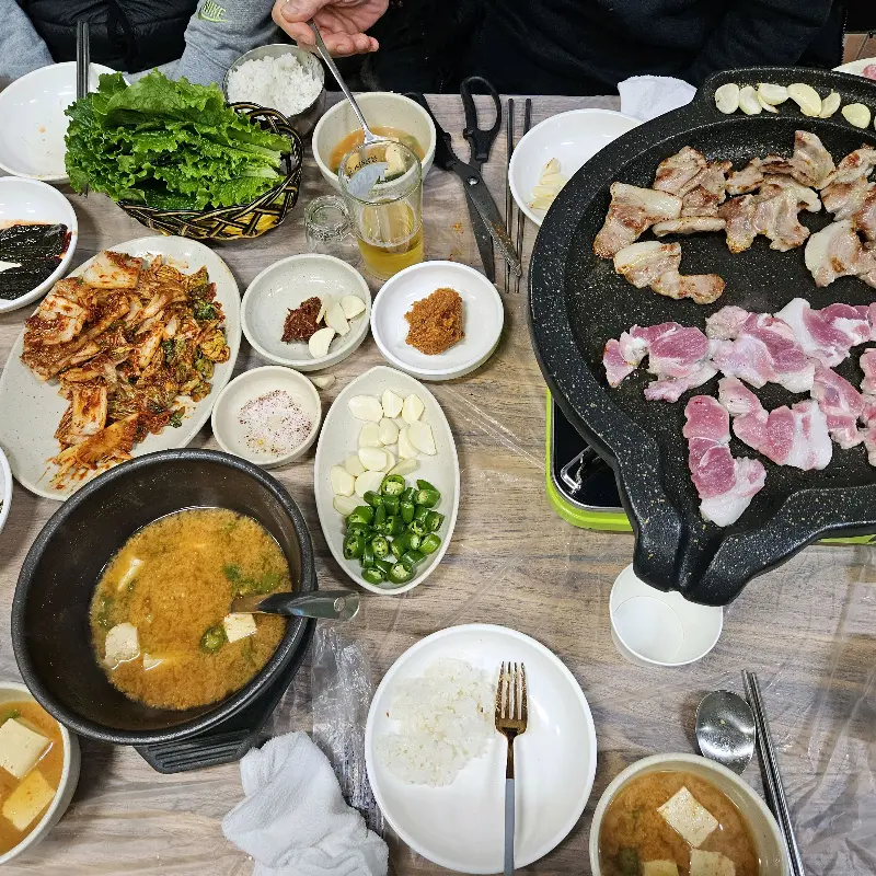 다채로운 밑반찬과 꼬들살, 된장찌개가 차려진 테이블 전경