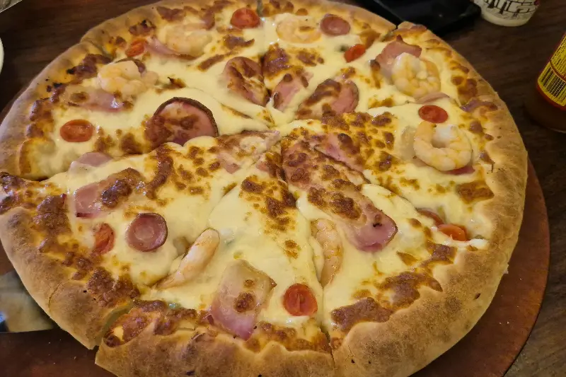 새우와 햄이 토핑된 피자의 클로즈업 사진