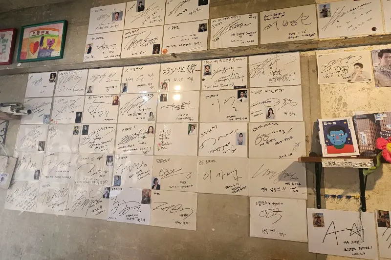드림랜드 분식 내부 벽면에 붙어있는 방문객들의 사진과 사인