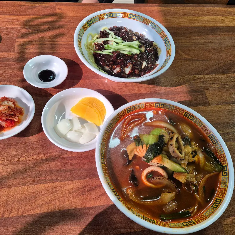 테이블 위에 놓여진 짬뽕, 짜장면, 단무지, 김치