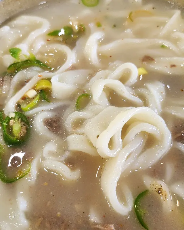 뽀얀 사골 국물에 소고기가 듬뿍 올려진 손칼국수