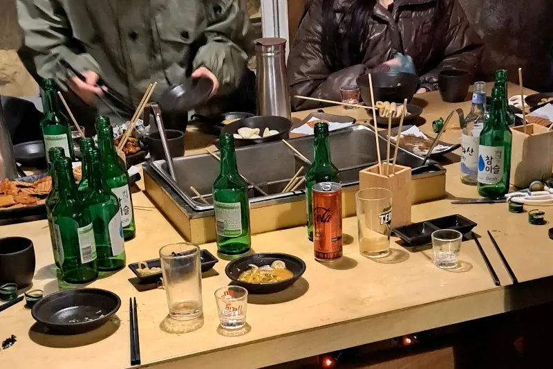 테이블 가득 놓인 음식과 술병