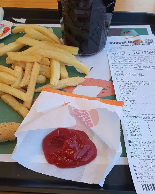 케첩이 뿌려진 감자튀김과 콜라