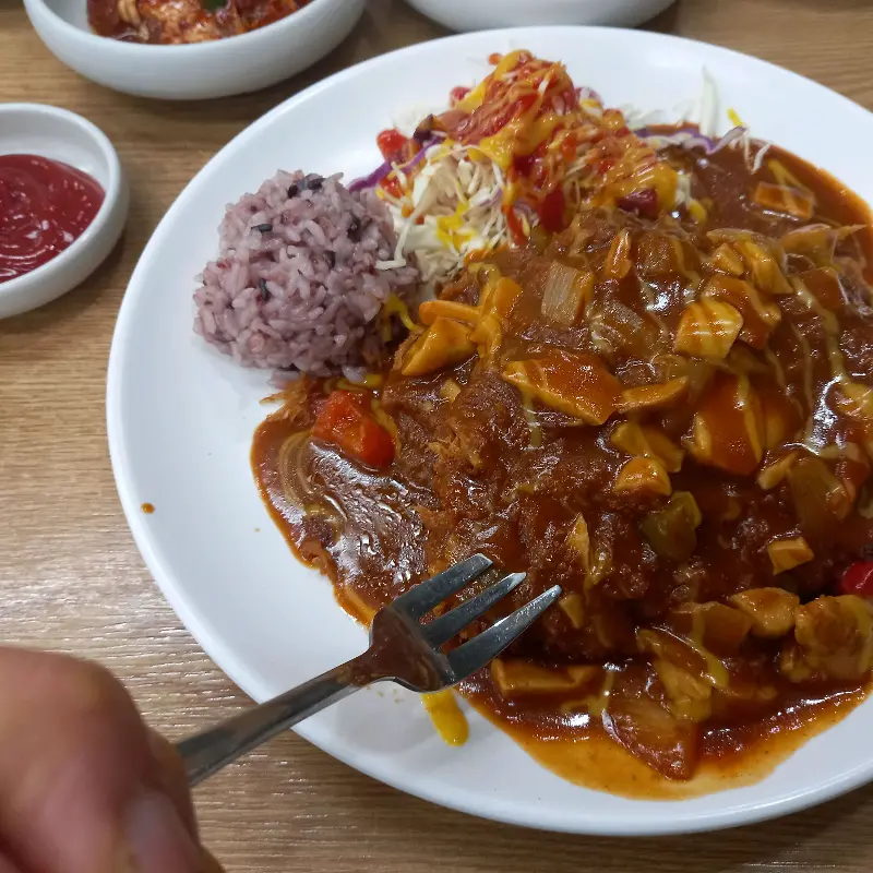 돈까스 위에 소스가 듬뿍 뿌려진 모습