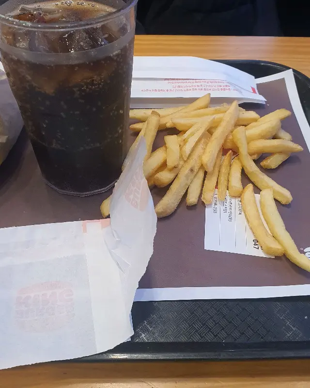 쟁반 위에 놓인 감자튀김과 콜라