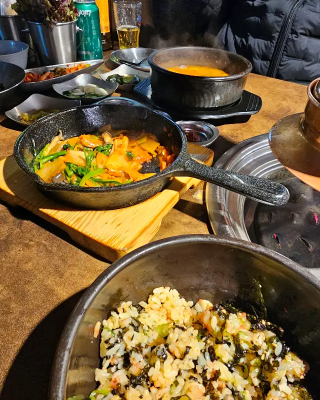 철판 김치, 명란밥, 된장찌개가 놓인 푸짐한 테이블