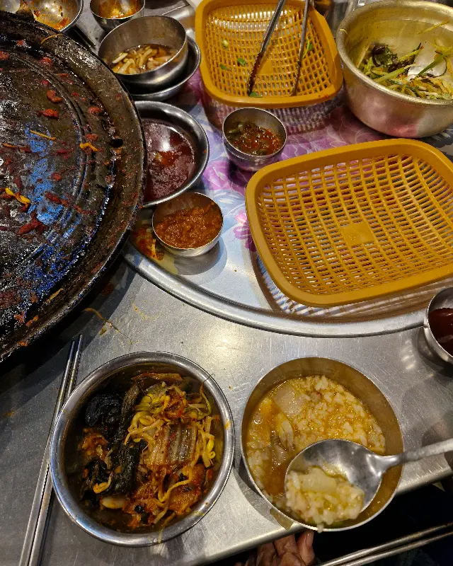 솥뚜껑 위에 구워진 김치와 콩나물