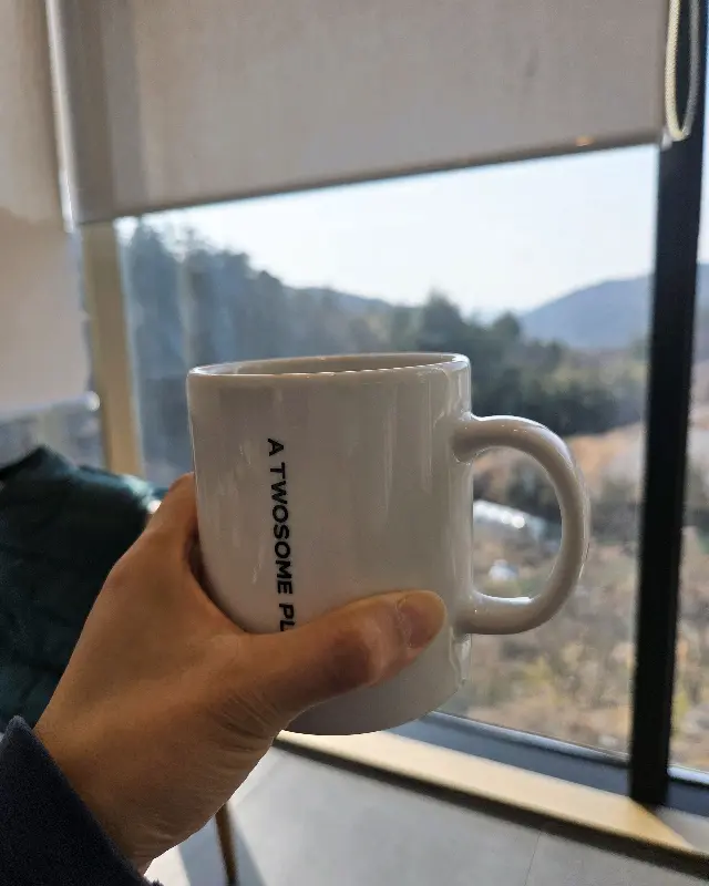 손에 들린 투썸플레이스 금정산성점 머그컵