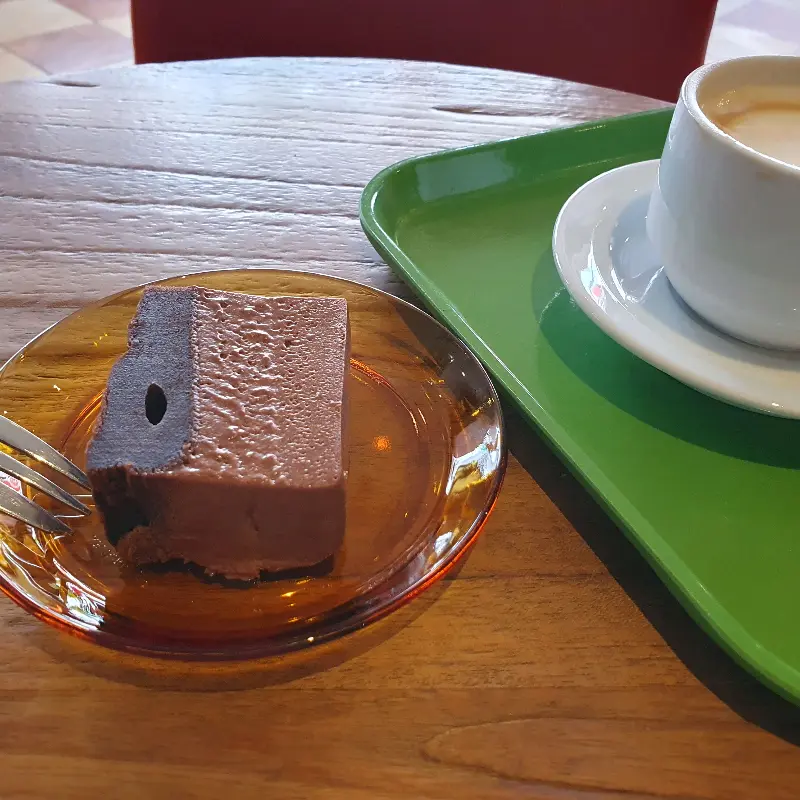 테이블 위에 놓인 초콜릿 케이크와 라떼