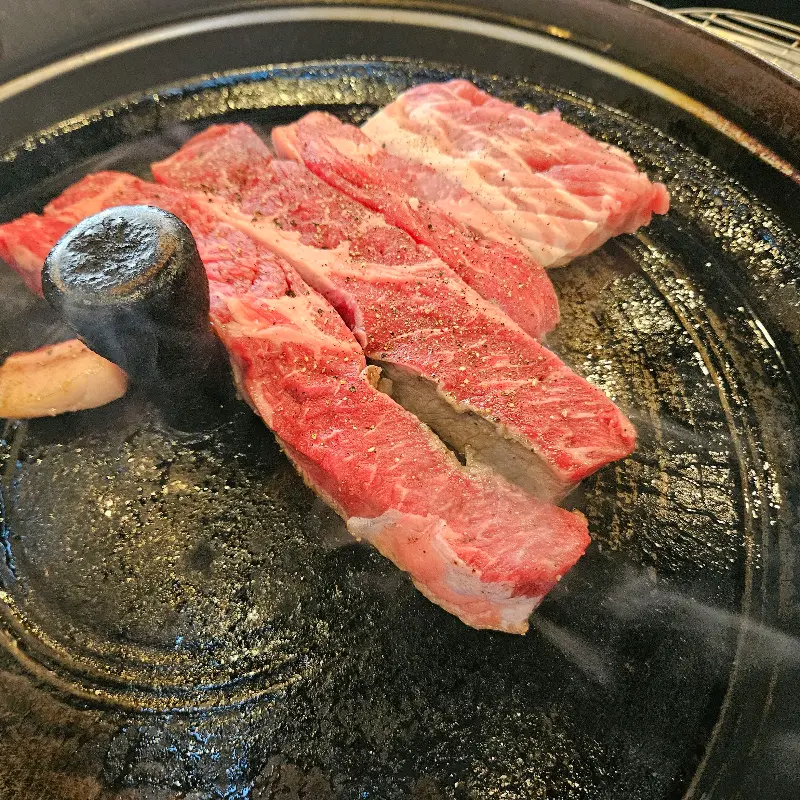 솥뚜껑 위에서 익어가는 고기
