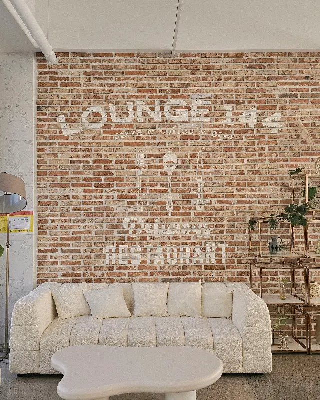 벽돌 벽에 흰색 글씨로 쓰여진 LOUNGE 144