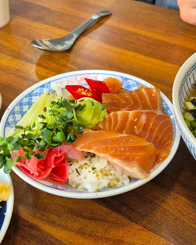 두툼하게 썰린 연어와 신선한 채소가 조화롭게 담긴 사케동