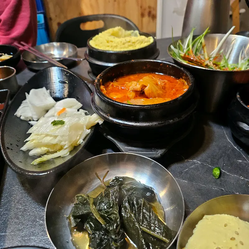 다채로운 밑반찬이 테이블 가득 놓여있는 모습