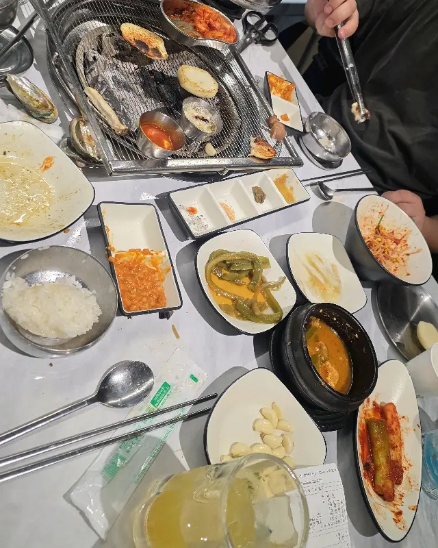 다양한 곁들임 메뉴와 쌈 채소가 놓인 테이블 전경