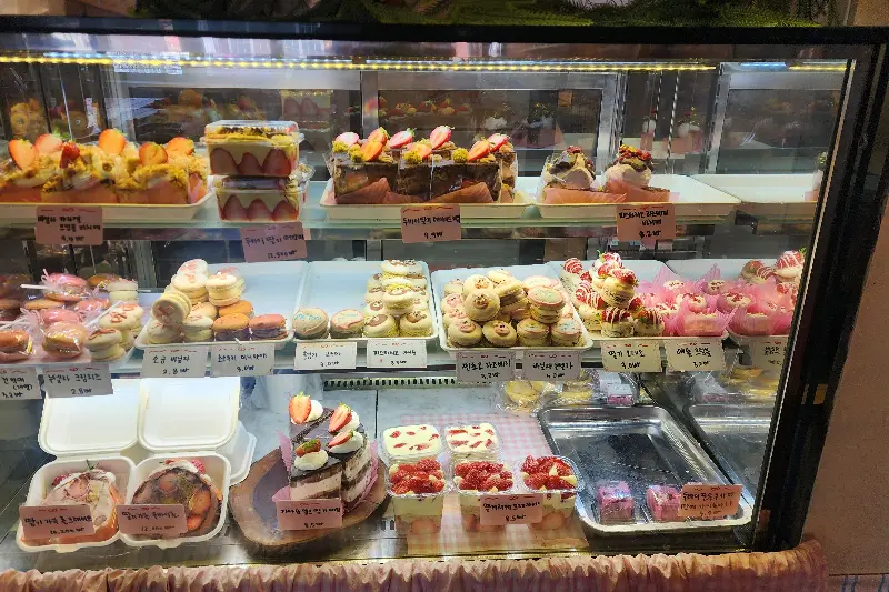 쇼케이스에 진열된 다양한 마카롱과 케이크