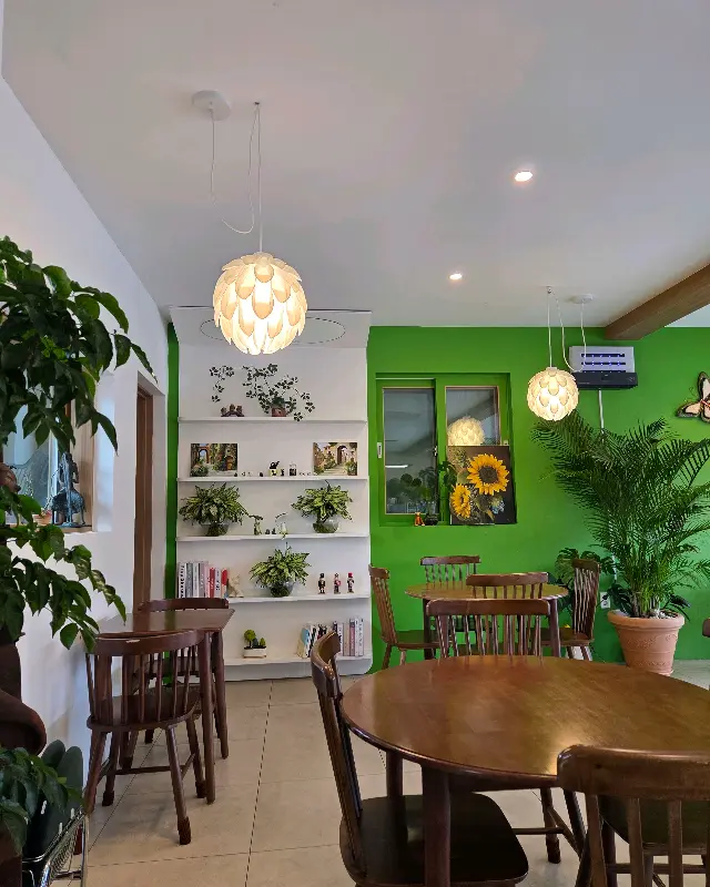 카페 내부 테이블과 초록색 벽