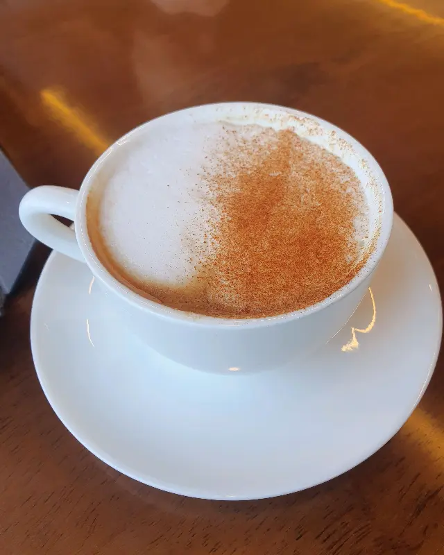 시나몬 가루가 뿌려진 따뜻한 라떼