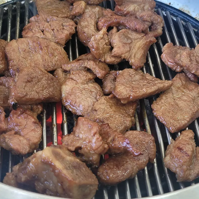 숯불 위에서 노릇노릇하게 익어가는 돼지갈비