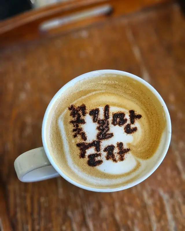 커피잔에 적힌 '오늘도 꽃길만 걸으세요'라는 문구가 인상적이다.