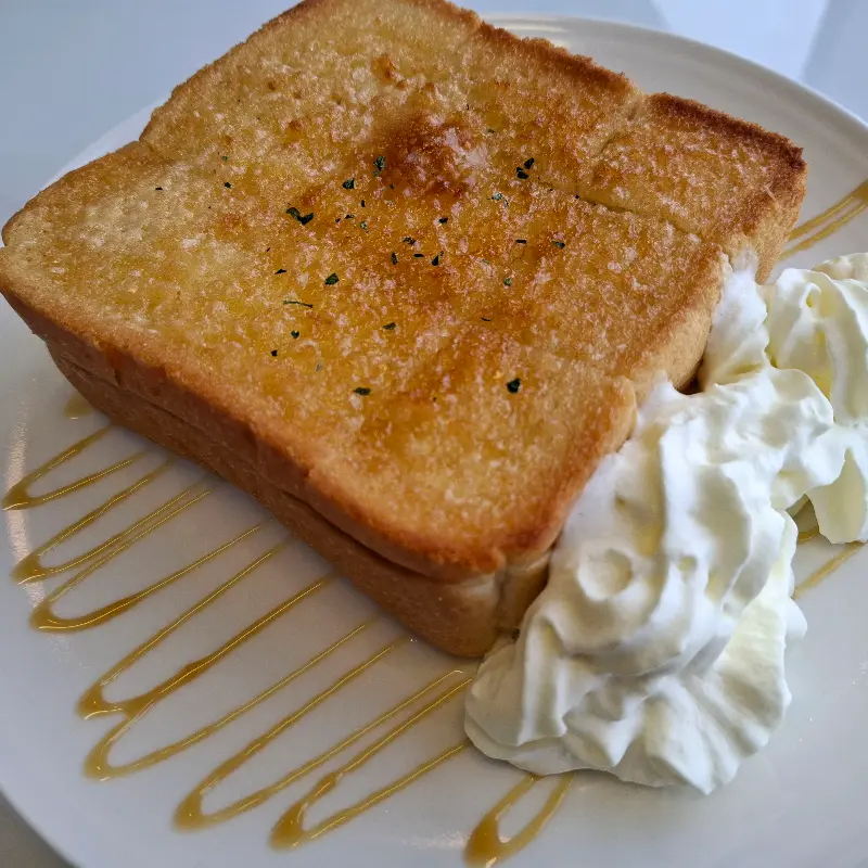 달콤한 시럽과 부드러운 생크림이 곁들여진 토스트