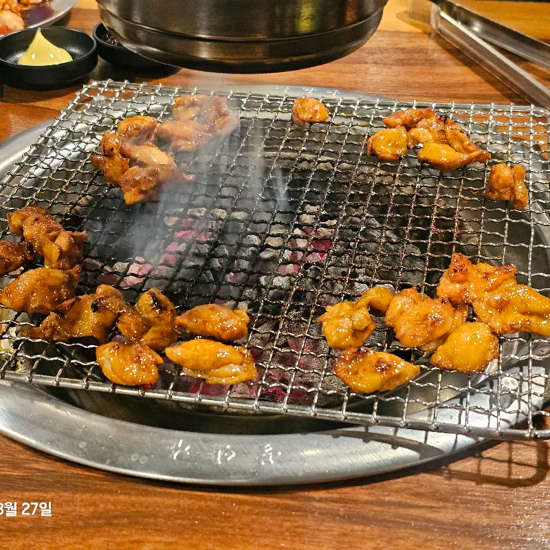 숯불 위에서 노릇하게 익어가는 닭 특수부위