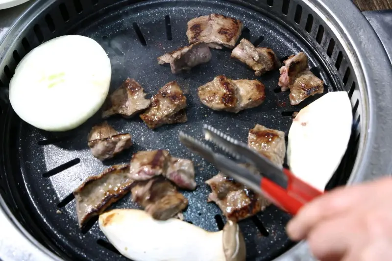 숯불 위에서 구워지는 돼지갈비와 버섯, 양파