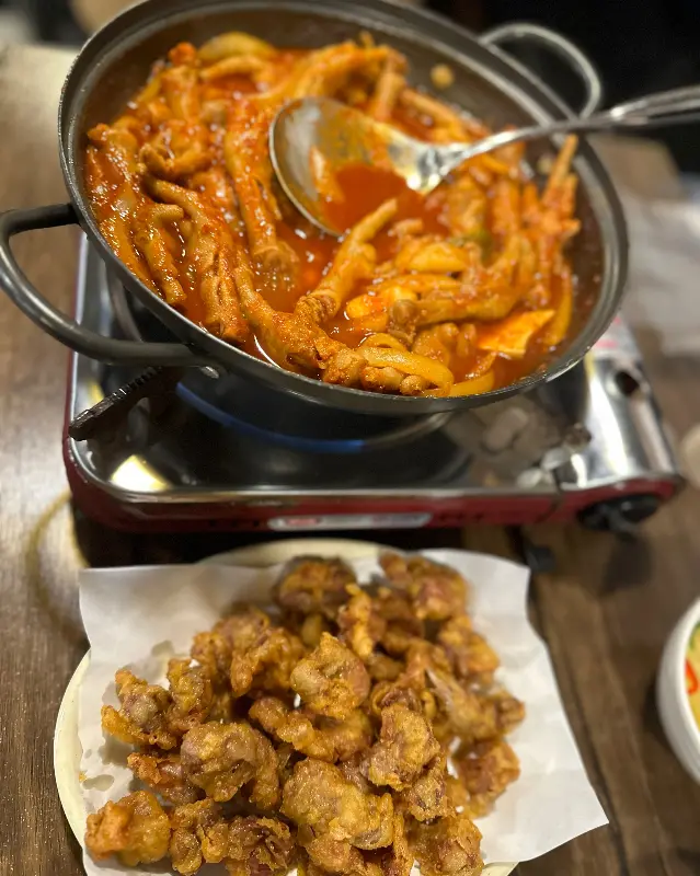 닭발과 닭똥집 튀김이 함께 놓여 있는 사진. 매콤함과 고소함의 완벽한 조화가 느껴진다.