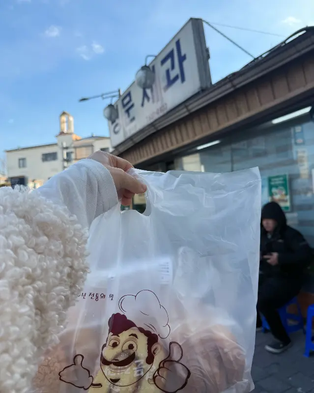 빵 봉투를 들고 있는 모습