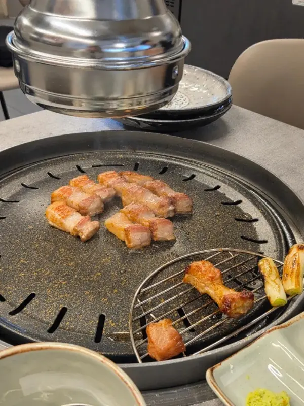 불판 위에 가지런히 놓인 삼겹살