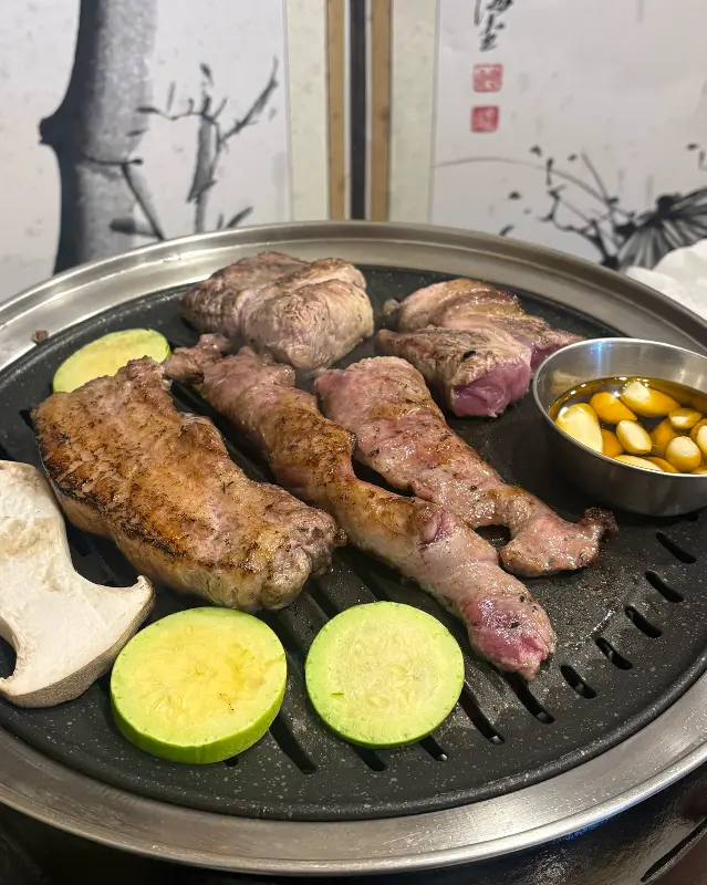 초벌된 고기를 불판에 올린 모습