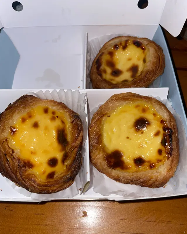 종이 포장 박스 안에 담긴 에그타르트 3개의 모습