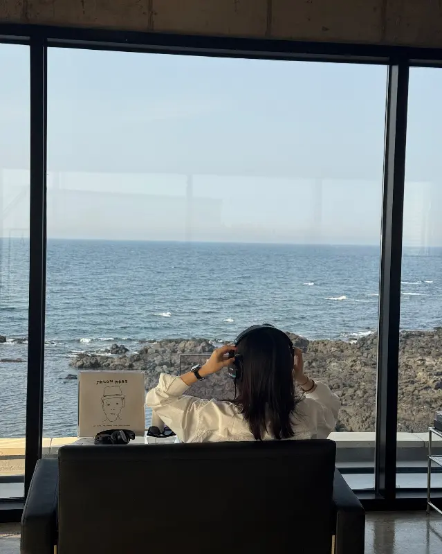 헤드폰을 끼고 음악을 감상하는 사람의 뒷모습