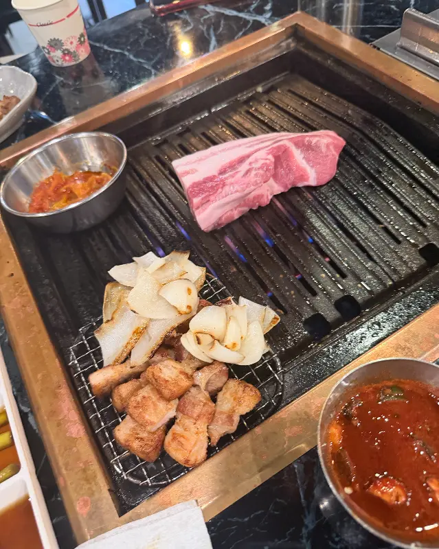 두툼한 통삼겹살이 불판 위에 올려져 있는 모습