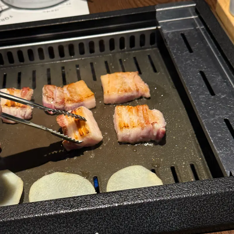 불판 위에서 노릇하게 구워지고 있는 삼겹살