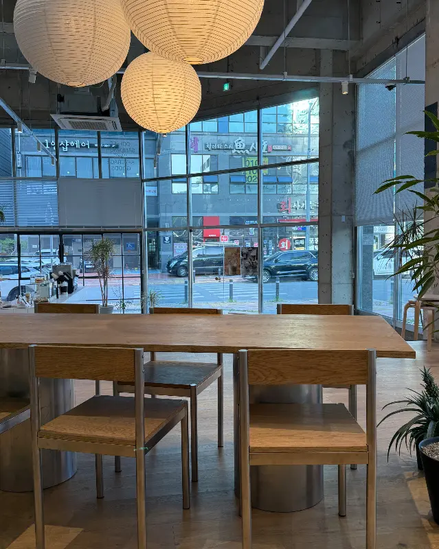 넓은 테이블과 편안한 의자가 놓여 있는 카페 내부