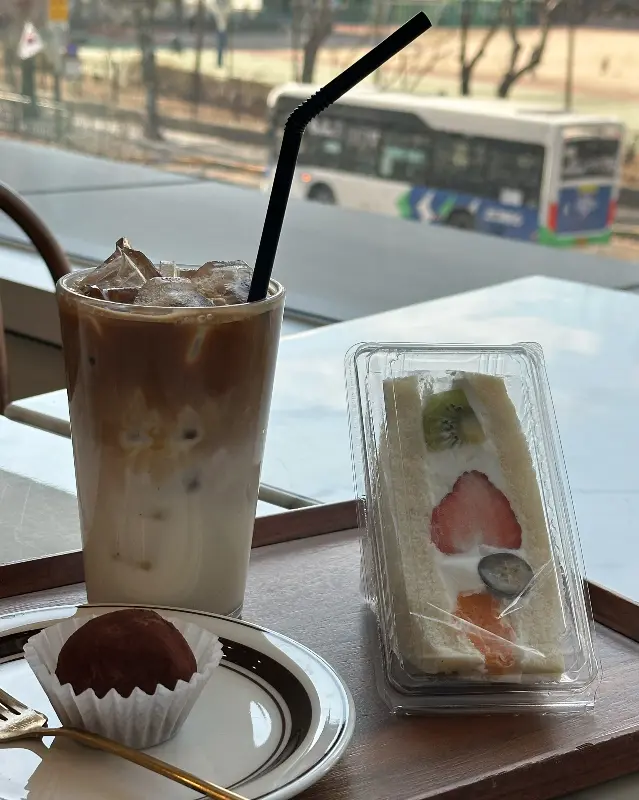 후르츠 산도와 라떼, 트러플이 함께 놓인 쟁반