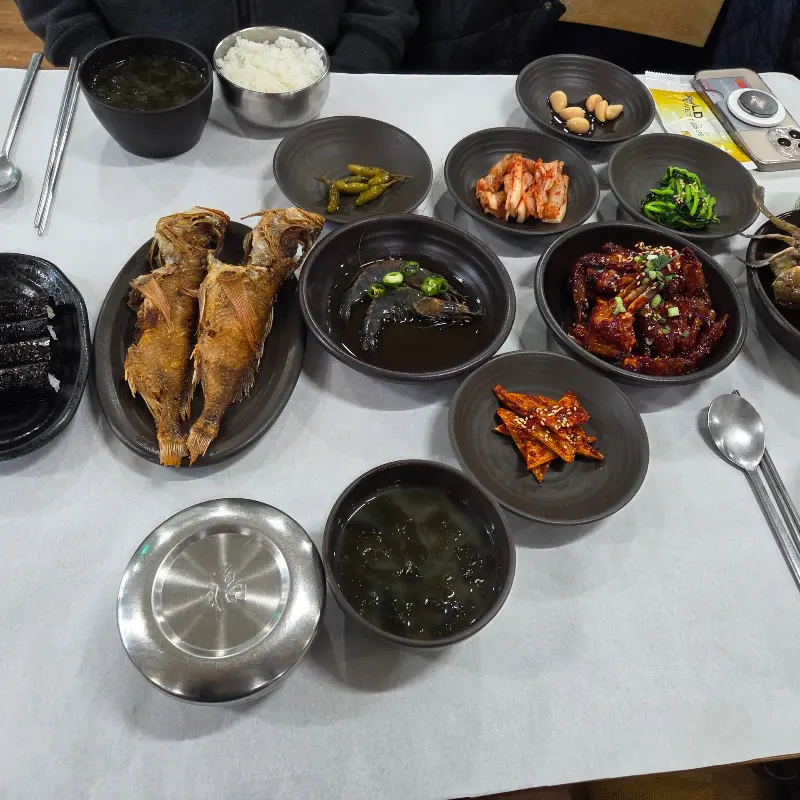 다양한 밑반찬과 생선구이가 함께 차려진 모습