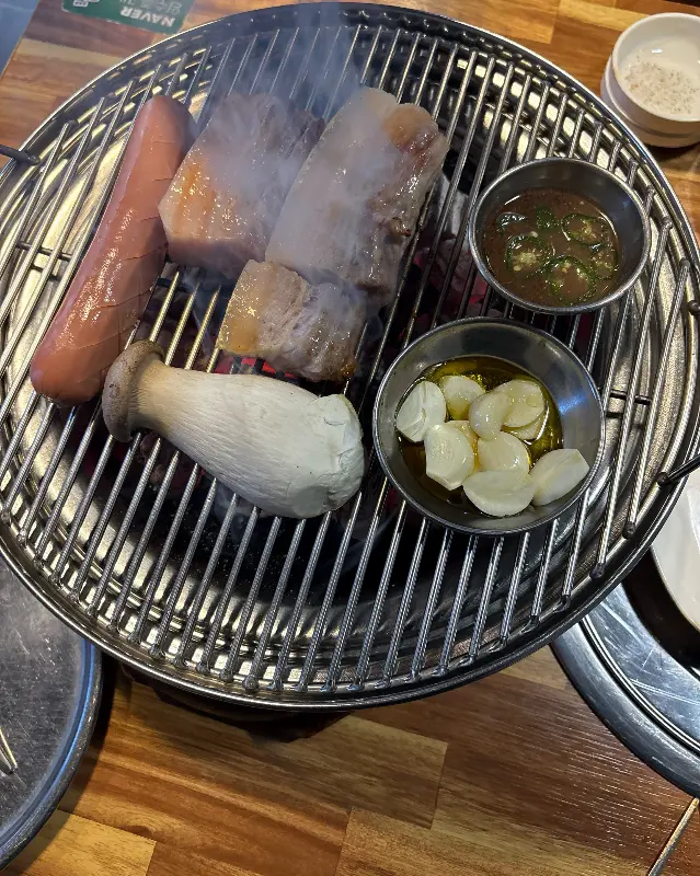 흑돼지 오겹살과 소세지, 버섯이 구워지는 모습