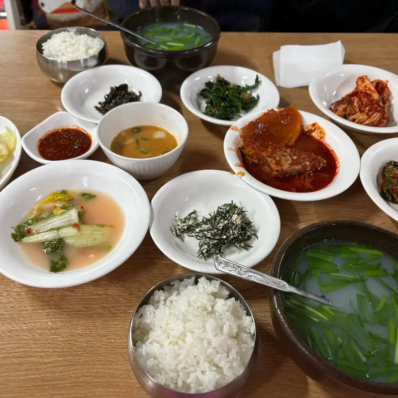 다채로운 밑반찬과 재첩국, 밥 한 공기가 차려진 푸짐한 상차림