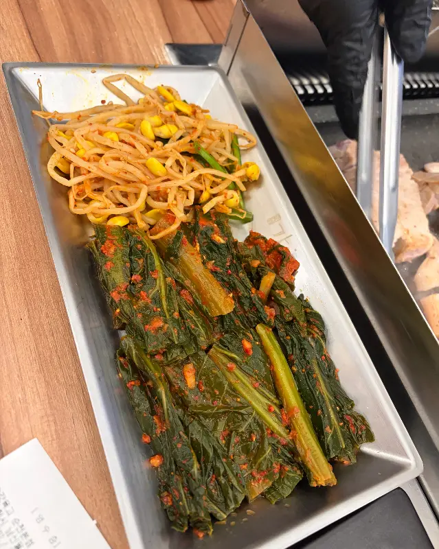 갓김치와 콩나물이 담겨져 나오는 모습