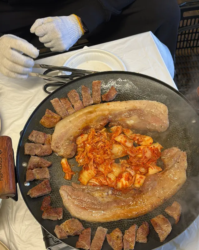 맛있게 구워진 삼겹살과 김치를 함께 먹는 모습