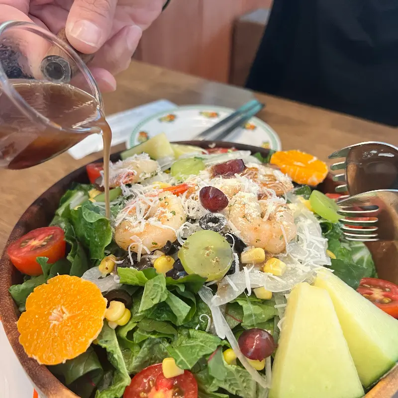 샐러드에 드레싱을 뿌리는 모습